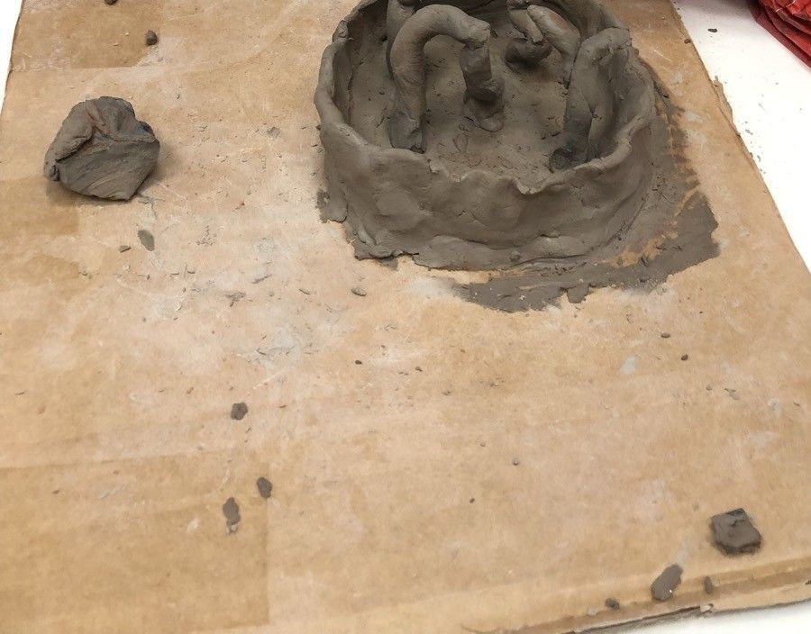 Un modelage en argile posé sur une plaque de carton