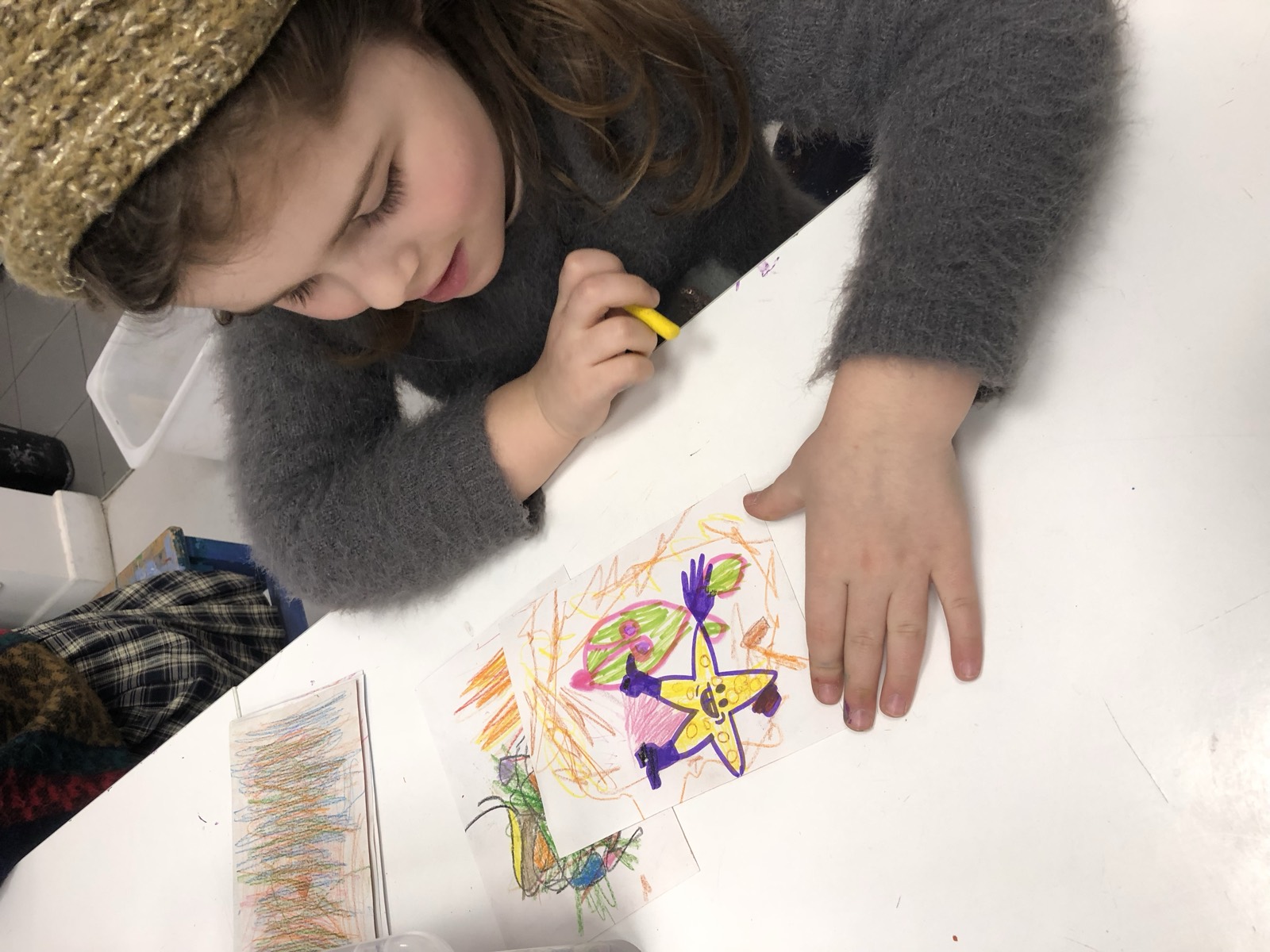 Un enfant dessine au feutre sur une feuille