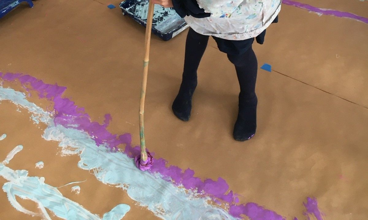 Des traces de peinture sur un grand papier kraft au sol